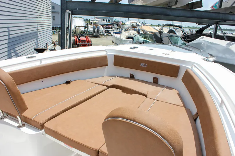Slide: The Image of 2026 Sea Hunt Ultra 265 SE boat with tan cushioned seating in marina setting. - 38
