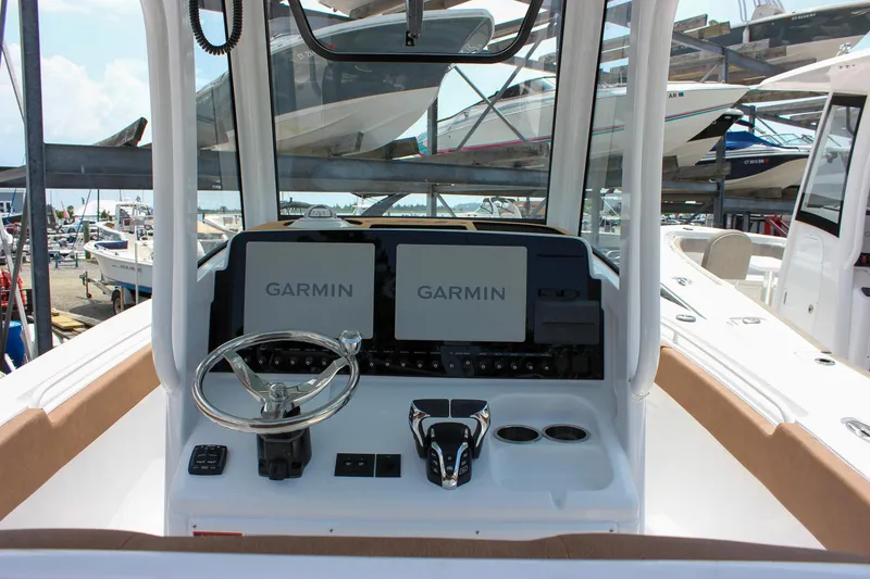 Slide: The Image of 2026 Sea Hunt Ultra 265 SE boat dashboard with Garmin navigation displays. - 4