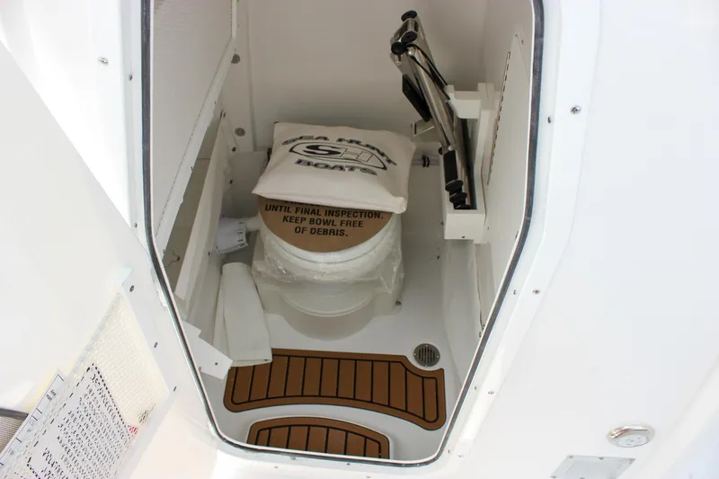 Slide: The Image of 2026 Sea Hunt Ultra 265 SE boat interior with covered toilet and wooden flooring. - 40