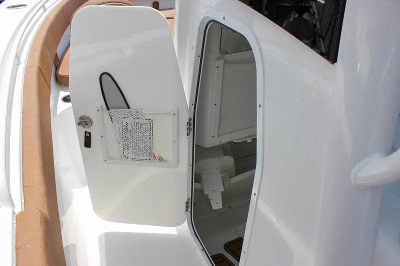 Slide: The Image of 2026 Sea Hunt Ultra 265 SE boat interior storage compartment with open door. - 42