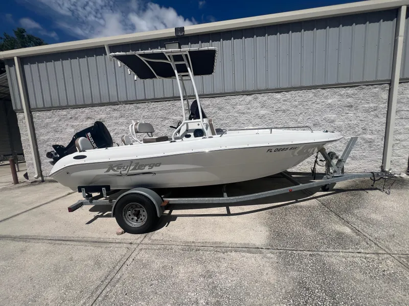 Slide: The Image of 2021 Key Largo 1801 CC boat on trailer, parked outdoors under a clear sky. - 0