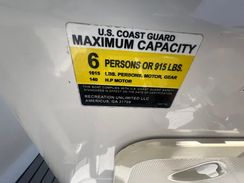 Slide: The Image of U.S. Coast Guard capacity label on 2021 Key Largo 1801 CC boat, 6 persons or 915 lbs. - 13