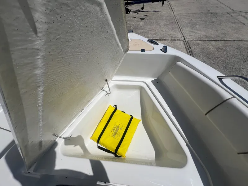 Slide: The Image of Open storage compartment on 2021 Key Largo 1801 CC boat with yellow life jacket. - 18