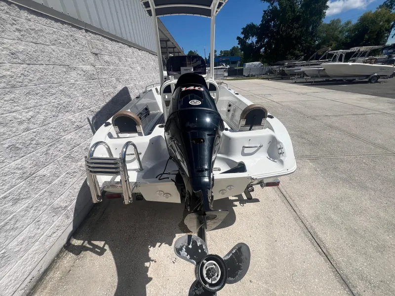 Slide: The Image of 2021 Key Largo 1801 CC boat with outboard motor, parked outdoors. - 4