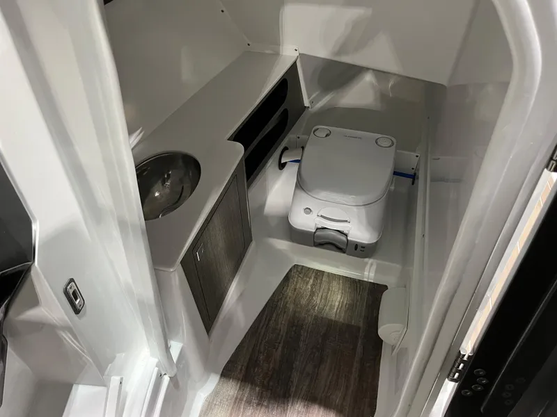 Slide: The Image of 2023 Monterey 298 Super Sport boat interior with compact bathroom and sink. - 14