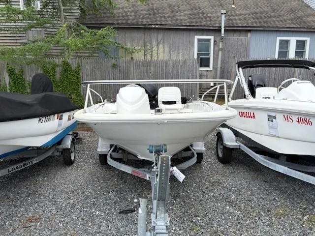Slide: The Image of 2016 Boston Whaler 130 SS boat on trailer, parked between two other boats. - 4