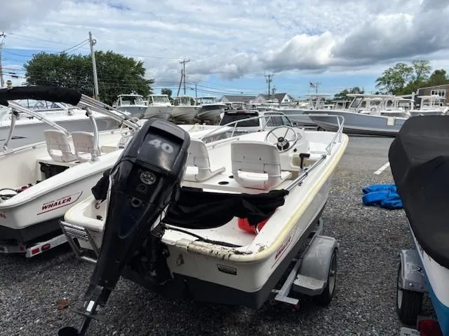 Slide: The Image of 2016 Boston Whaler 130 SS boat with 40 HP engine on trailer, parked outdoors. - 5