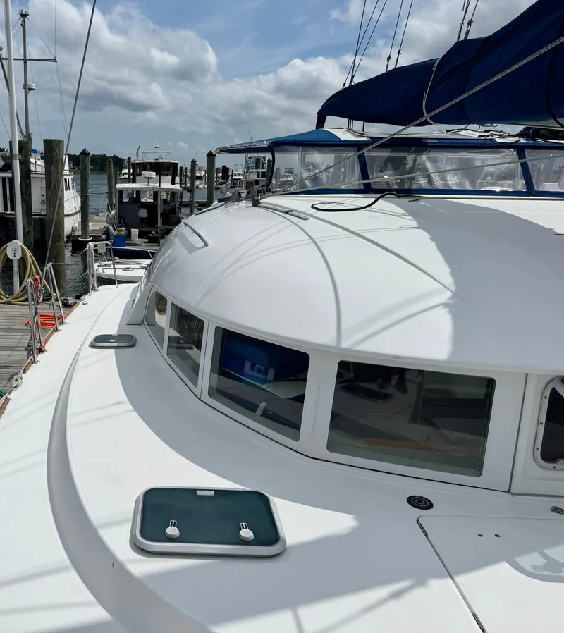 Slide: The Image of Lagoon 380 catamaran docked at marina, showcasing sleek design and spacious deck. - 10