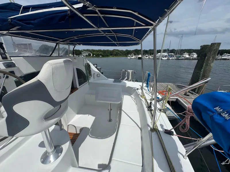 Slide: The Image of Lagoon 380 catamaran cockpit with seating, docked at marina, under blue canopy. - 13