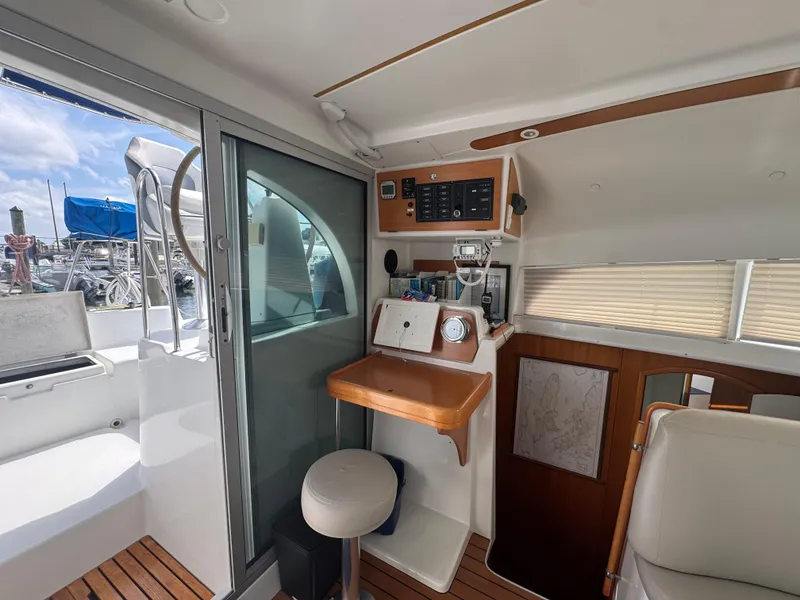 Slide: The Image of Interior of 2000 Lagoon 380 catamaran with navigation station and marina view. - 16