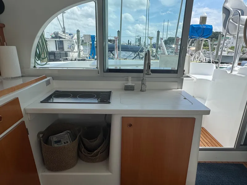 Slide: The Image of Interior view of Lagoon 380 catamaran kitchen with stove and sink, overlooking marina. - 18