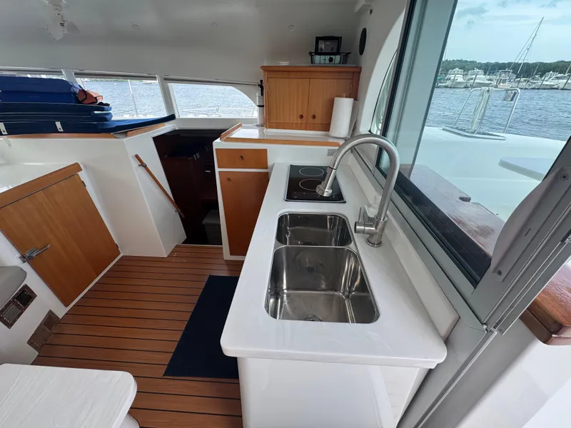 Slide: The Image of Interior of 2000 Lagoon 380 catamaran featuring kitchen sink, stove, and wooden cabinetry. - 19