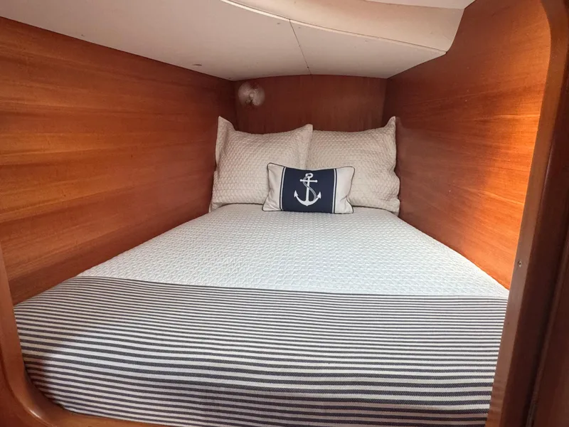 Slide: The Image of Cozy cabin bed in 2000 Lagoon 380 catamaran with nautical-themed decor. - 23
