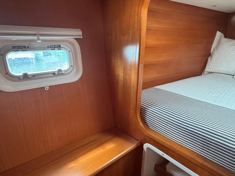 Slide: The Image of Interior cabin of 2000 Lagoon 380 catamaran with wooden finish and cozy bed. - 24