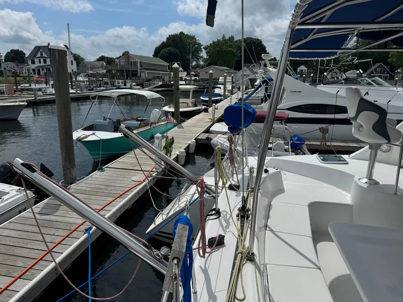 Slide: The Image of Docked Lagoon 380 catamaran from 2000, surrounded by other boats in a marina. - 7
