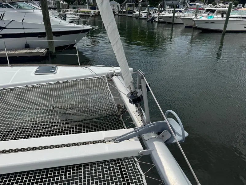 Slide: The Image of Lagoon 380 catamaran docked in marina, showcasing anchor and netting, 2000 model. - 8