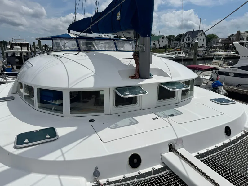 Slide: The Image of Lagoon 380 catamaran from 2000 docked at a marina under a partly cloudy sky. - 9