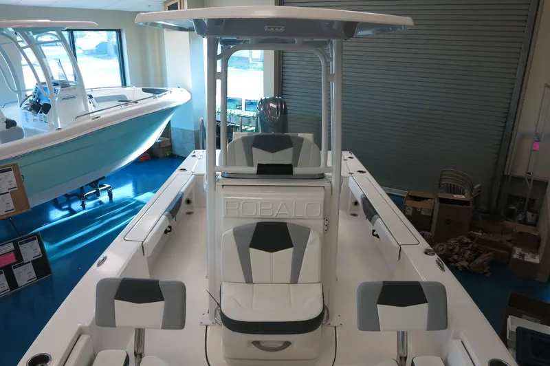 Slide: The Image of 2025 Robalo 226 Cayman boat interior with seating and console in showroom. - 18
