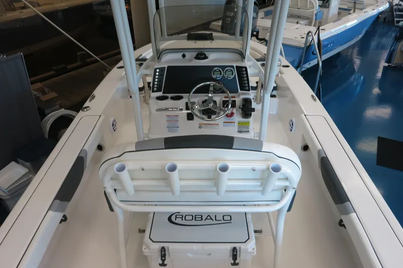 Slide: The Image of 2025 Robalo 226 Cayman boat interior with steering console and rod holders. - 23