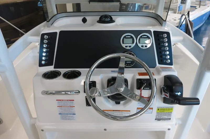 Slide: The Image of 2025 Robalo 226 Cayman boat dashboard with steering wheel and control panel. - 25