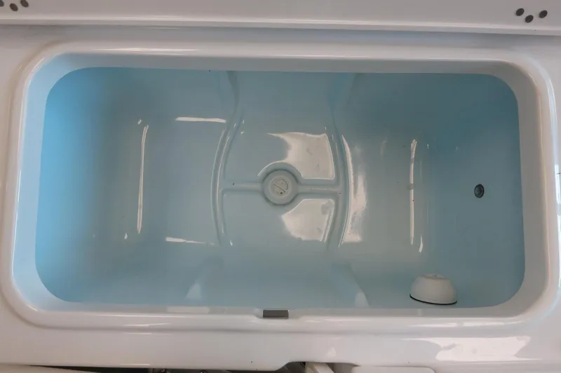 Slide: The Image of Livewell compartment in 2025 Robalo 226 Cayman boat, featuring a clean, white interior. - 27