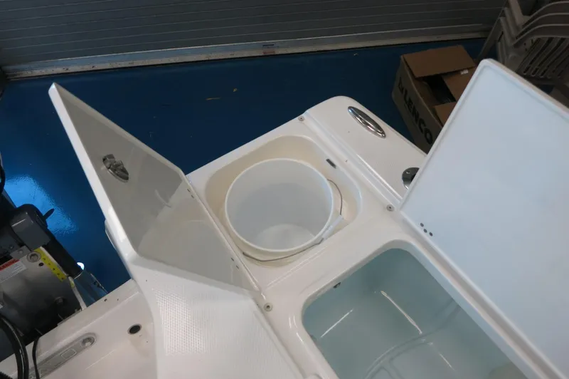 Slide: The Image of 2025 Robalo 226 Cayman boat storage compartments with open lids and bucket. - 30