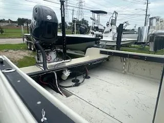 Slide: The Image of 1976 Boston Whaler 21 Outrage boat with Suzuki outboard motor, parked outdoors. - 11