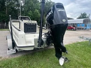 Slide: The Image of 1976 Boston Whaler 21 Outrage with Suzuki 200 engine on trailer, parked on grass. - 12