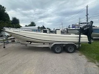 Slide: The Image of 1976 Boston Whaler 21 Outrage boat on trailer, parked outdoors under cloudy sky. - 3