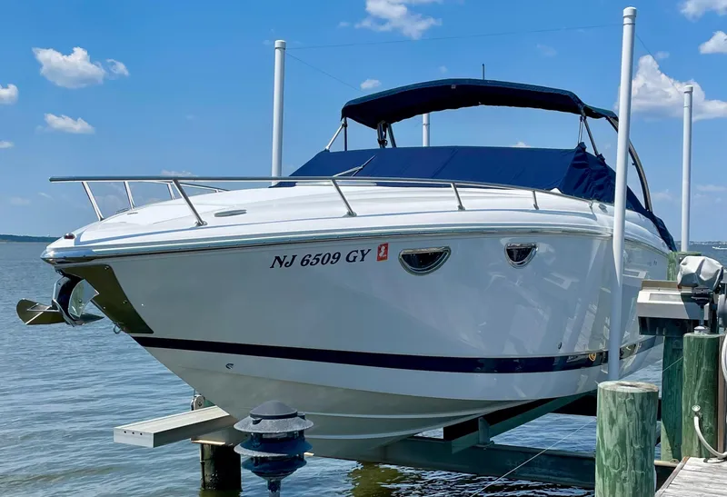 The Image of 2006 Cobalt 323 boat docked on a lift under a clear blue sky. - 0