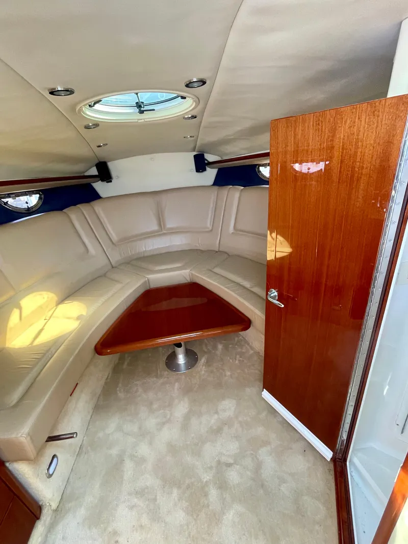 Slide: The Image of 2006 Cobalt 323 cabin interior with beige seating and wooden table. - 11