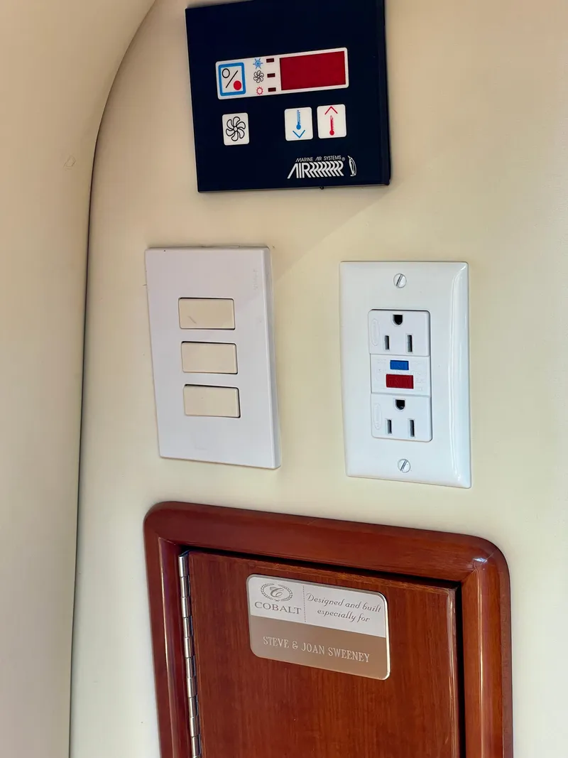 Slide: The Image of Control panel and outlets in a 2006 Cobalt 323 boat interior. - 12