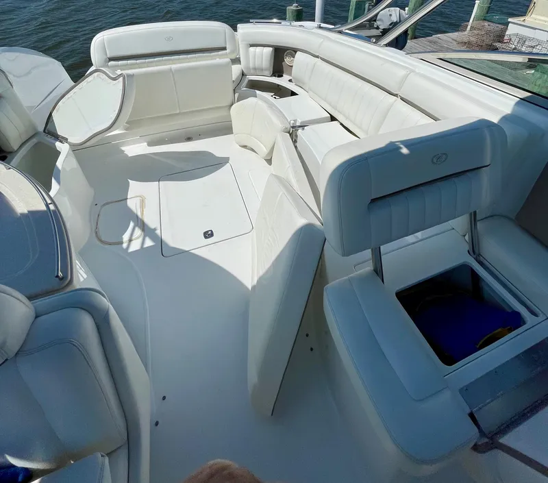 Slide: The Image of 2006 Cobalt 323 boat interior with white leather seating and storage compartments. - 14
