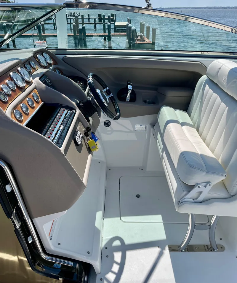 Slide: The Image of 2006 Cobalt 323 boat cockpit with steering wheel and control panel, docked by the water. - 22