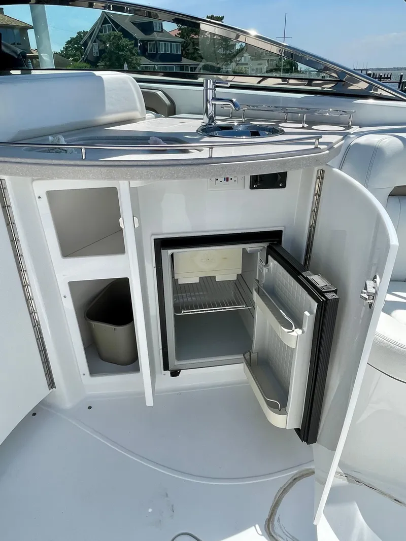 Slide: The Image of Open mini fridge on 2006 Cobalt 323 boat, showcasing sleek interior and storage compartments. - 26