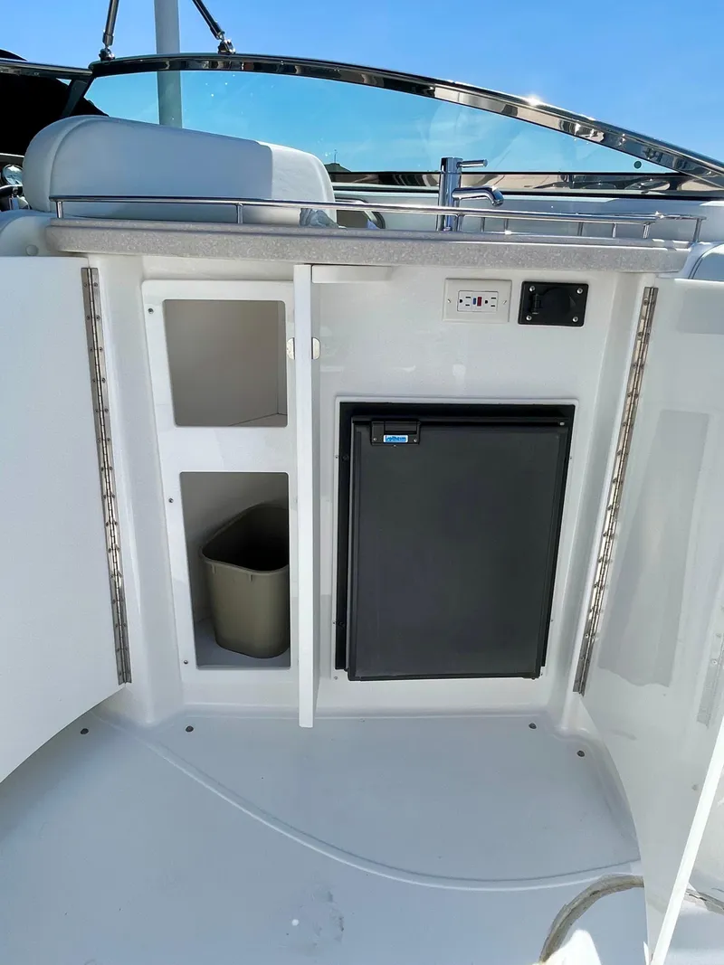 Slide: The Image of 2006 Cobalt 323 boat interior with mini fridge and storage compartments. - 27