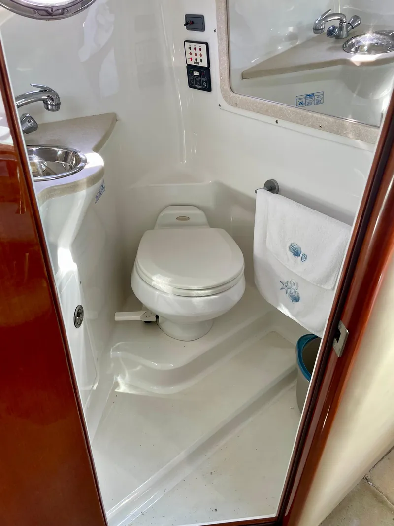 Slide: The Image of Compact bathroom in a 2006 Cobalt 323 boat, featuring a toilet and sink. - 31