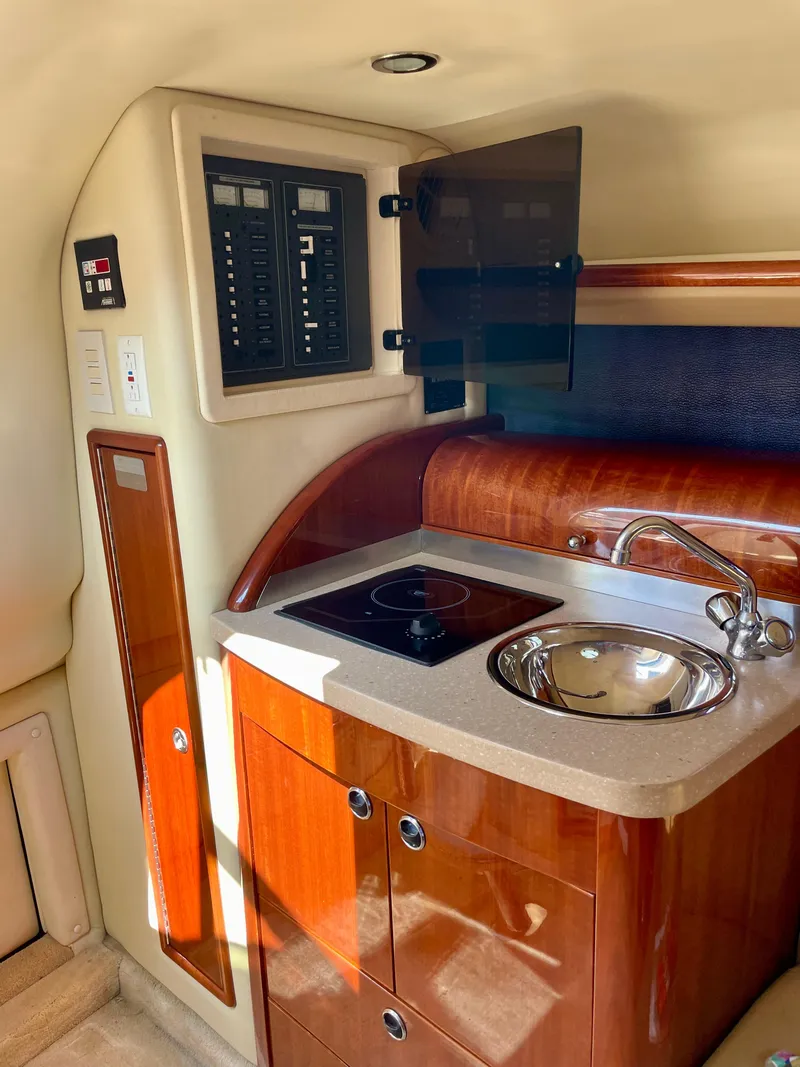 Slide: The Image of Luxurious 2006 Cobalt 323 yacht kitchen with stove, sink, and wood cabinetry. - 5