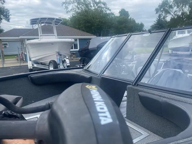 Slide: The Image of 2019 Starweld Fusion Pro 18 DC boat with Minn Kota motor, parked near a trailer and house. - 5