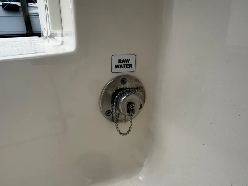 Slide: The Image of 2015 Cobia 237 Center Console raw water inlet with chain and label. - 15