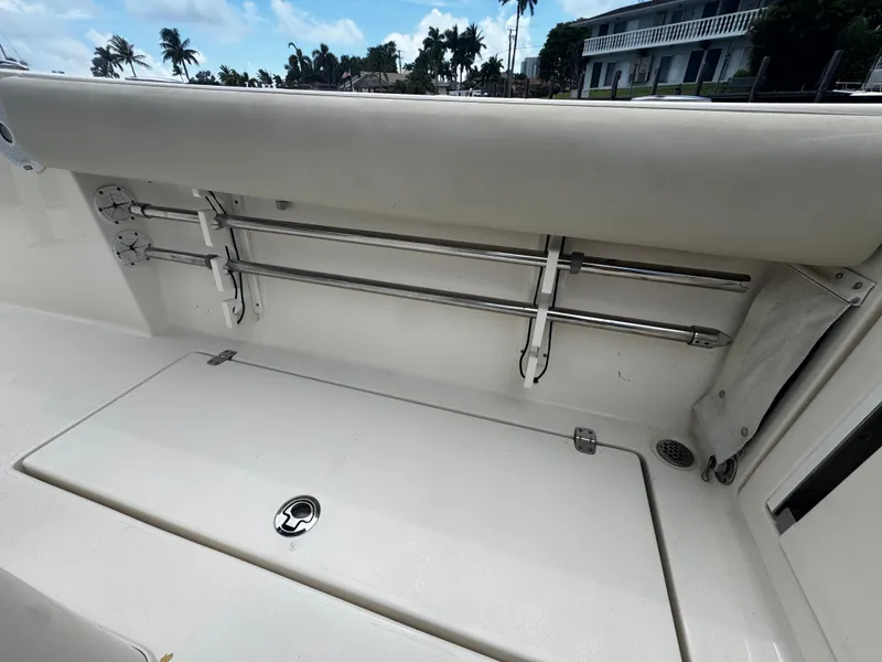 Slide: The Image of 2015 Cobia 237 Center Console boat interior with rod holders and storage compartment. - 18