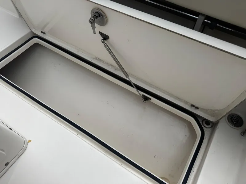Slide: The Image of Open storage compartment on 2015 Cobia 237 Center Console boat. - 19