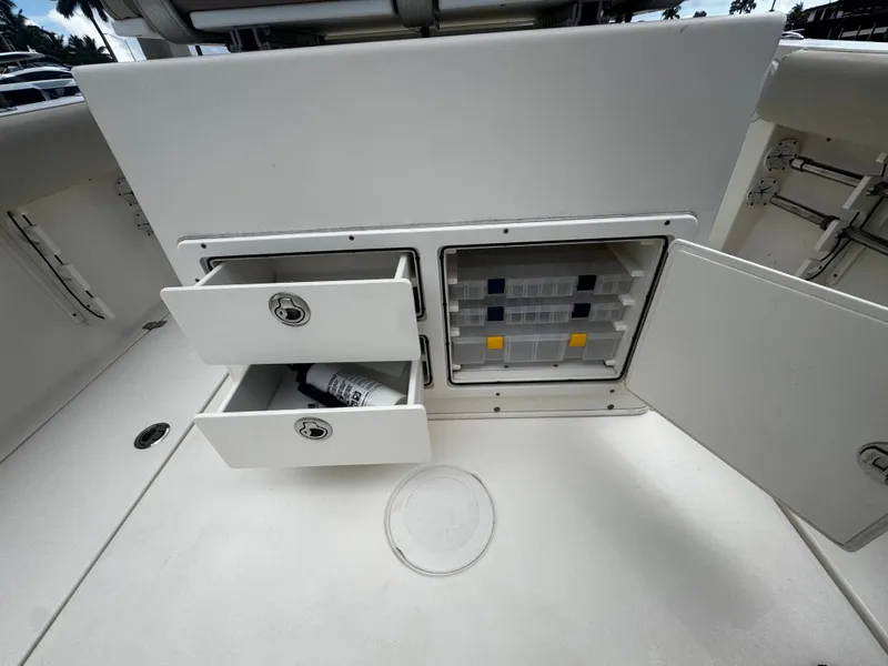 Slide: The Image of 2015 Cobia 237 Center Console storage compartments with drawers and tackle box. - 22