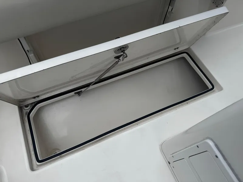 Slide: The Image of Open storage compartment on a 2015 Cobia 237 Center Console boat. - 24
