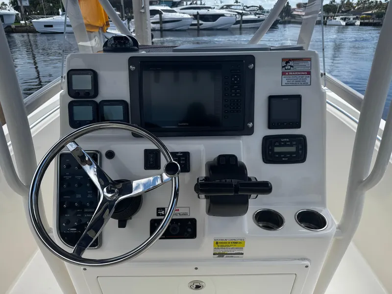 Slide: The Image of 2015 Cobia 237 Center Console boat dashboard with steering wheel and navigation controls. - 30