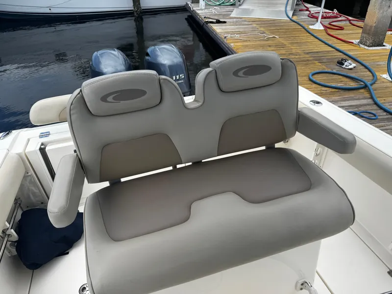 Slide: The Image of 2015 Cobia 237 Center Console boat seat with dual outboard motors in background. - 31