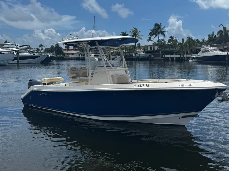 Slide: The Image of 2015 Cobia 237 Center Console boat on calm water, clear sky background. - 4