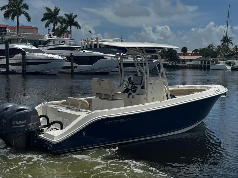Slide: The Image of 2015 Cobia 237 Center Console boat with Yamaha engines docked in a marina. - 9