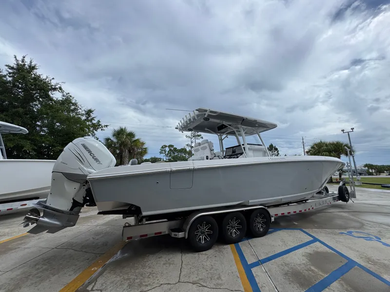 Slide: The Image of 2022 Fountain 38 CC boat on trailer, parked outdoors under cloudy sky. - 11