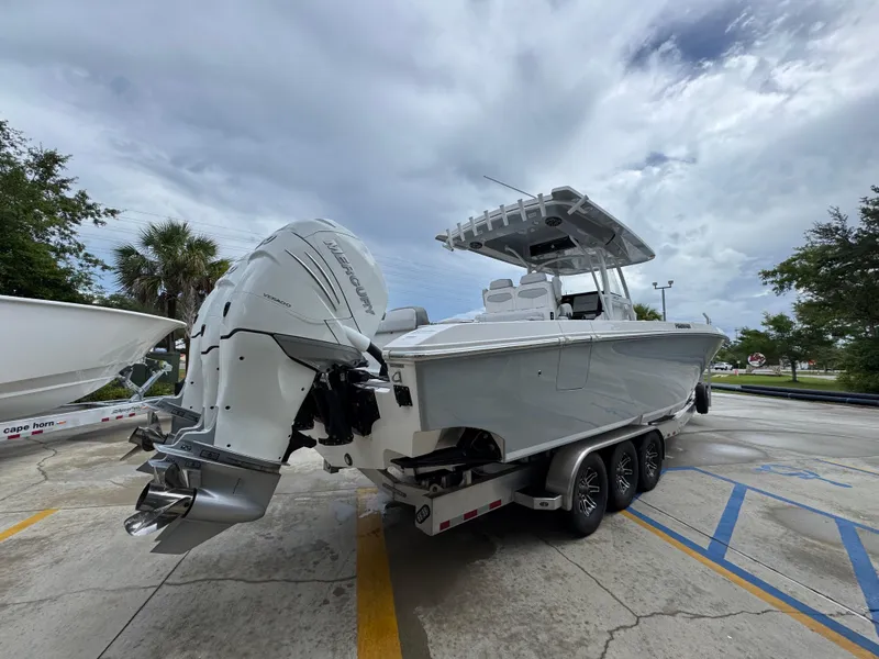 Slide: The Image of 2022 Fountain 38 CC boat with Mercury engines on a trailer, parked outdoors. - 12